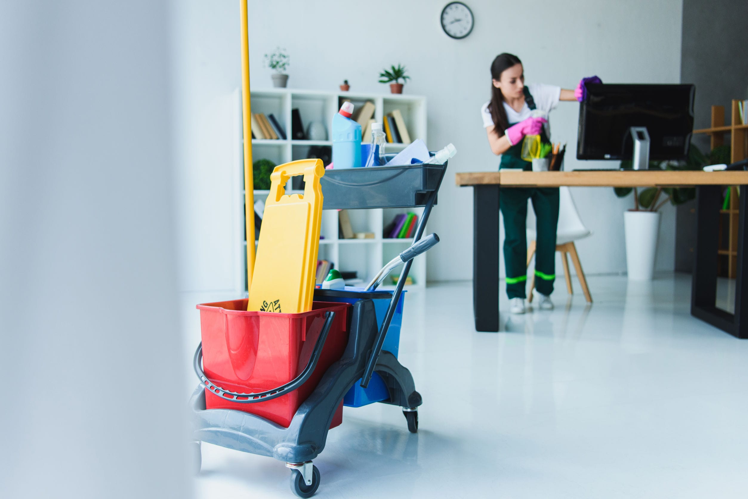 young female janitor cleaning office with various cleaning equipment young female janitor cleaning office with various cleaning equipment